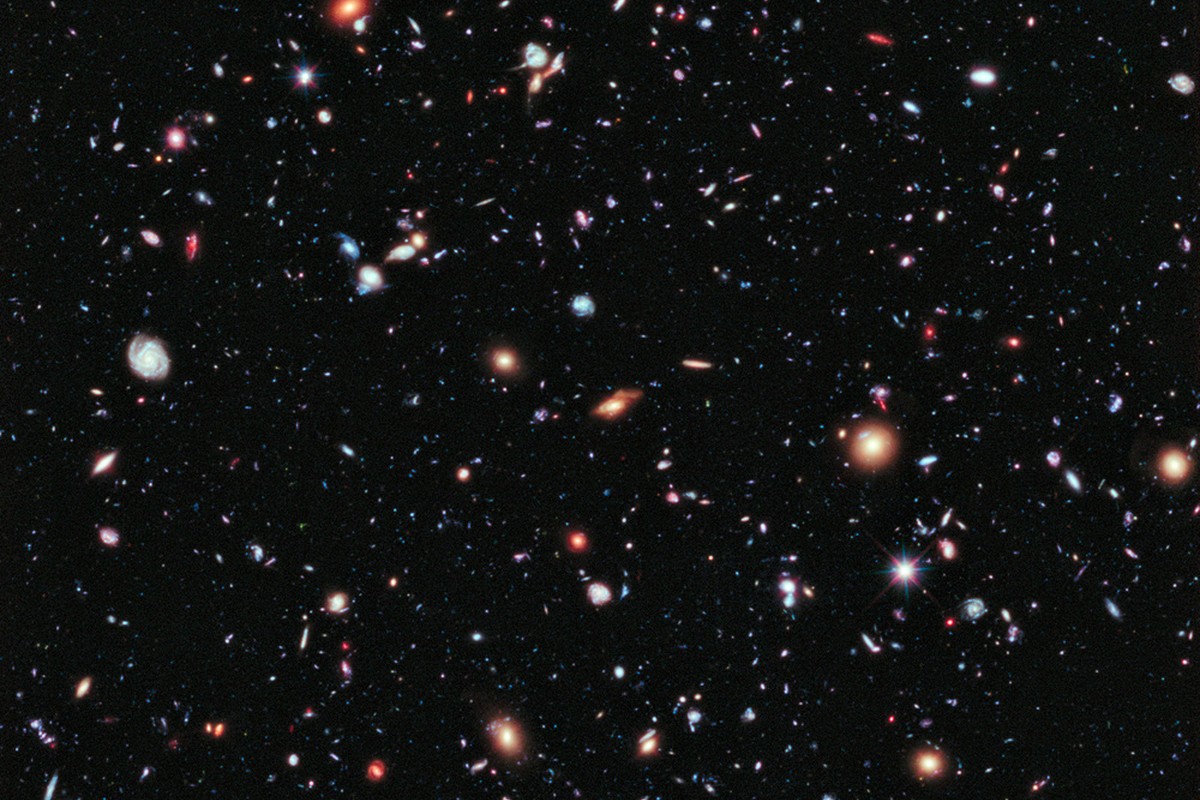 A dense field of stars and distant galaxies against a dark sky.